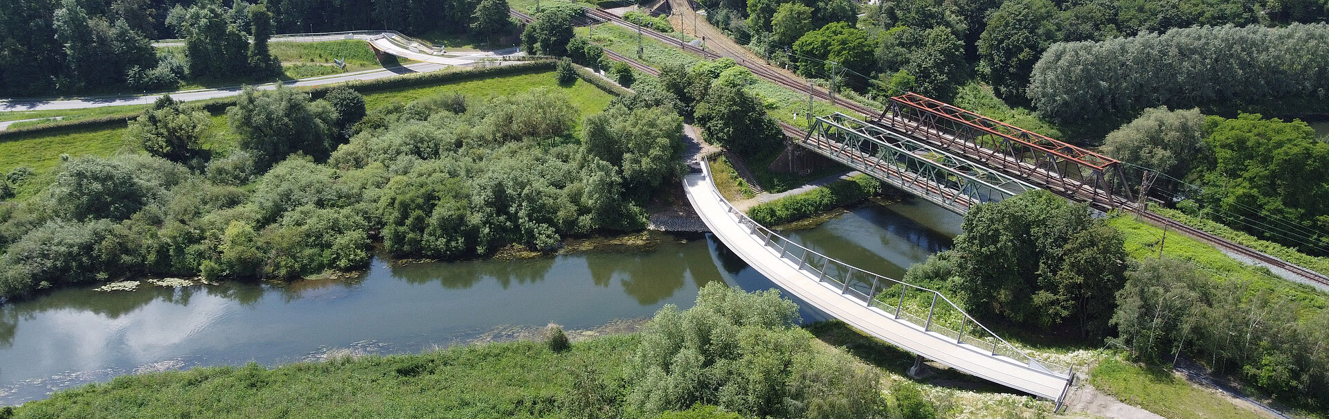 Luftaufnahme des Landschaftspark Viktoria in Lünen. Zu sehen ist eine Brücke über einem Fluß in einer grünen Landschaft.