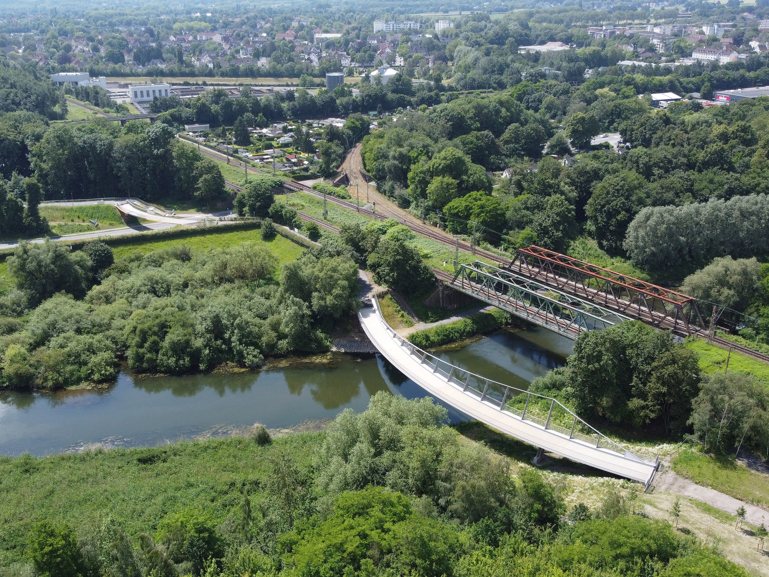 Luftaufnahme des Landschaftspark Viktoria in Lünen. Zu sehen ist eine Brücke über einem Fluß in einer grünen Landschaft.