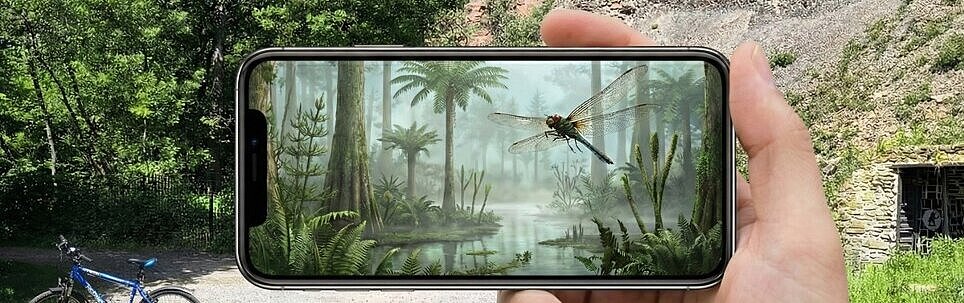 Landschaft mit einem Handy im Vordergrund auf dem eine KI-Visualisierung zu sehen ist