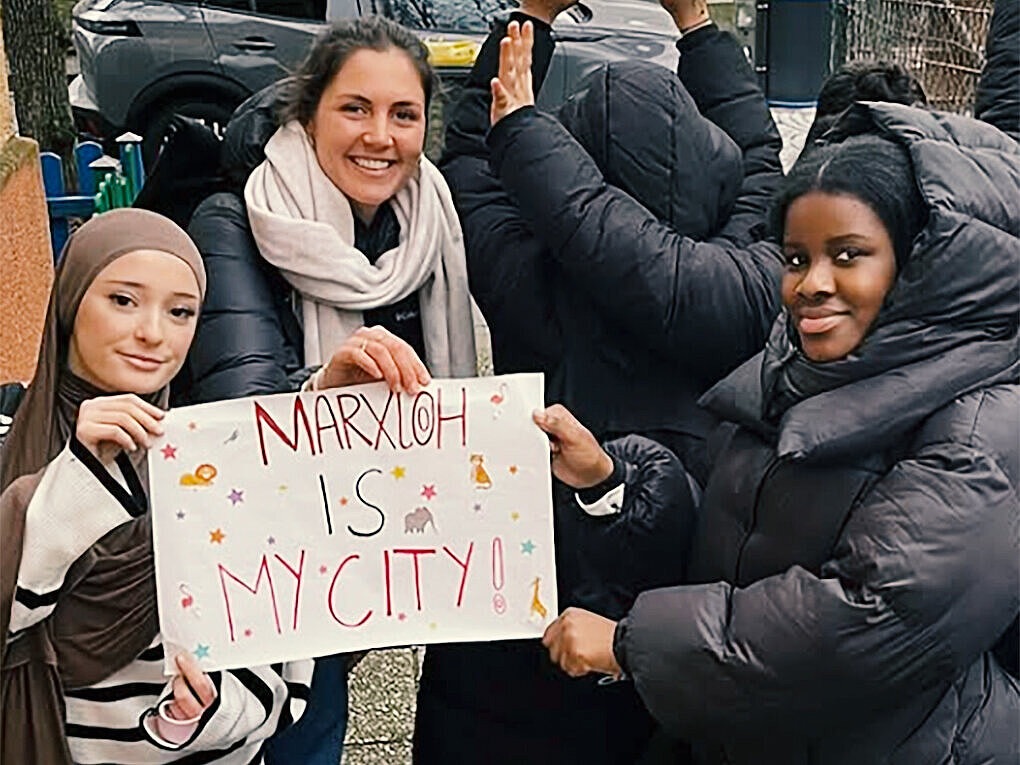 Mädchen und junge Frauen mit Migrationsgeschichte halten ein Schild mit der Aufschrift "Marxloh is my City" hoch