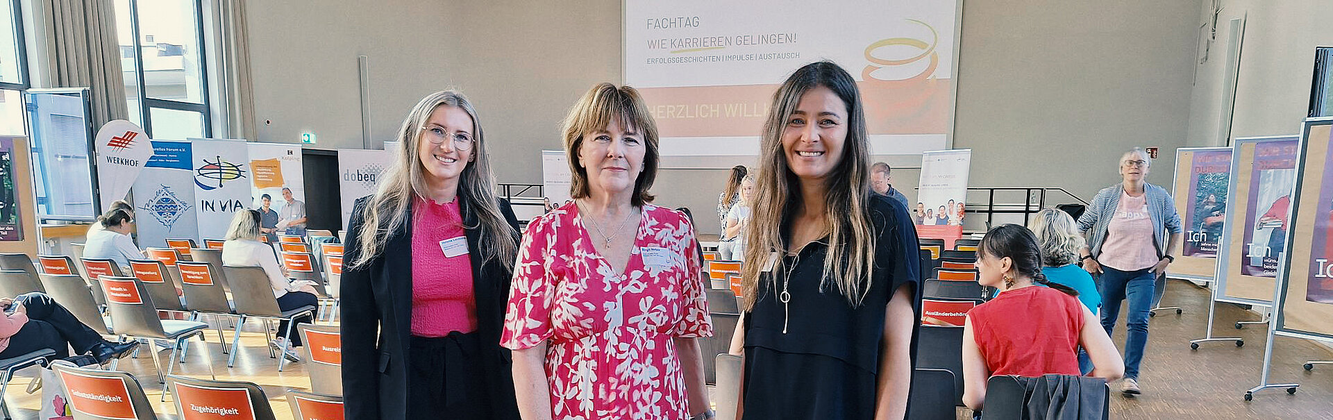 3 Frauen in einem Saal, in dem ein Workshop stattfindet