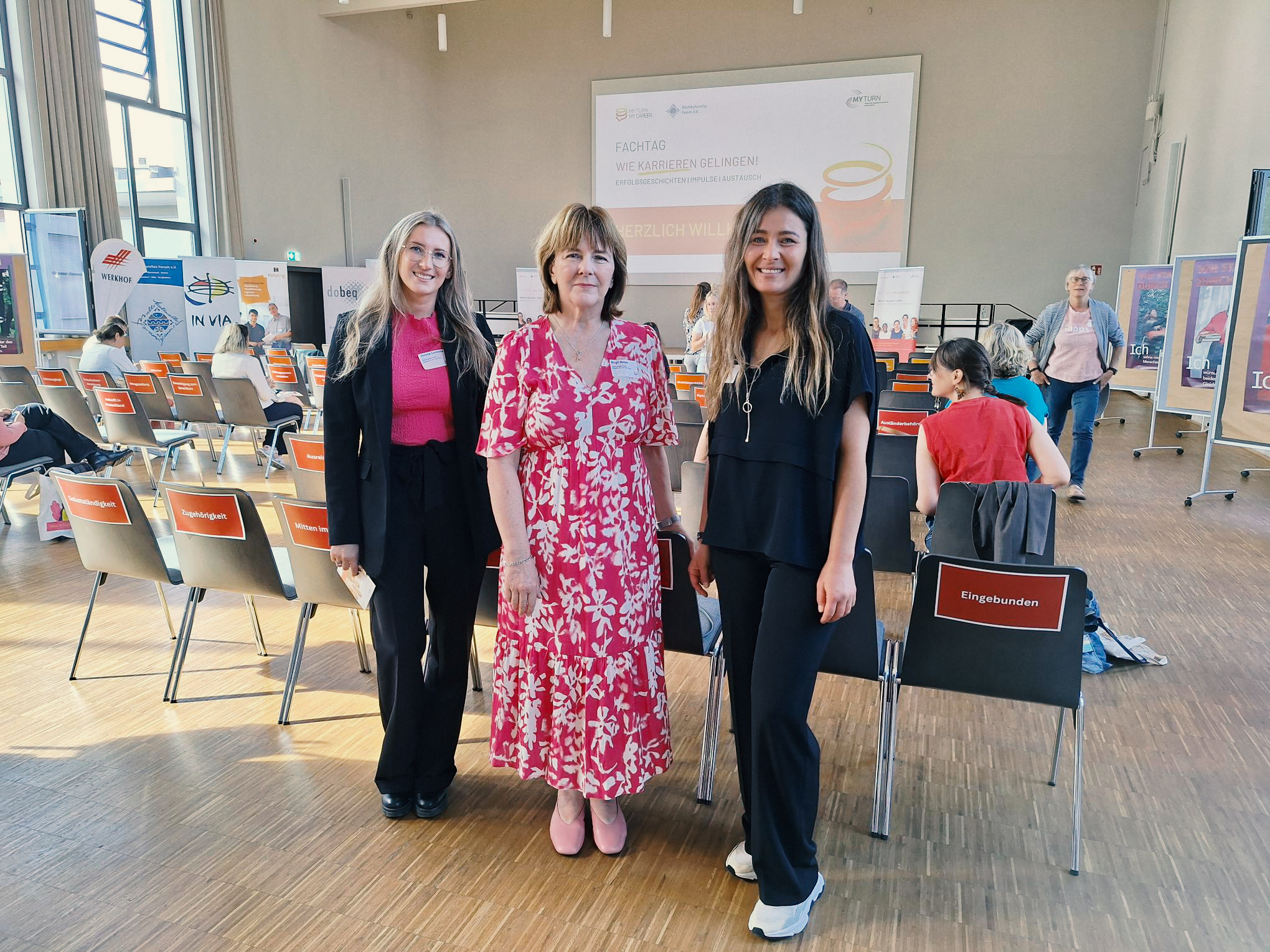 3 Frauen in einem Saal, in dem ein Workshop stattfindet